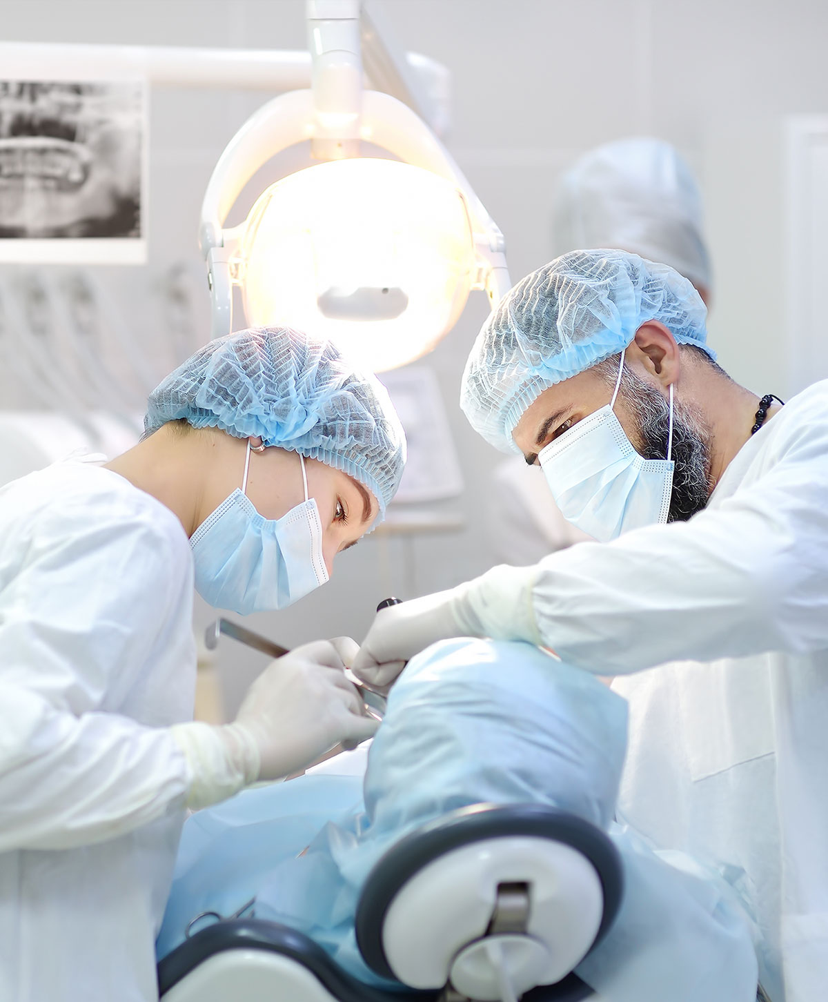 Dentisti effettuano intervento di chirurgia su paziente